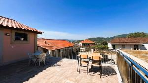 eine Terrasse mit Tisch und Stühlen auf einem Balkon in der Unterkunft Casa da Moura - Arcos de Valdevez in Arcos de Valdevez