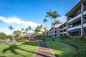 a walkway in front of a building with palm trees at Kaanapali Royal G201 FREE CAR KBM Resorts in Kaanapali