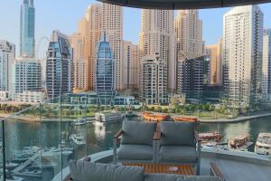 a balcony with two chairs and a view of a city at Casa Royale Vacation Home - Dubai Marina in Dubai