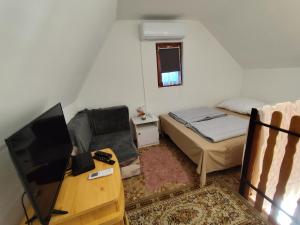 una piccola stanza con un letto e una televisione di BB House a Balatonboglár