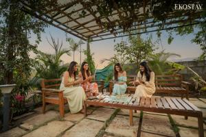 Casa Vayu 3 BHK - EKOSTAY في لونافالا: مجموعة نساء جالسات حول طاولة