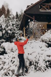 a person is shoveling snow from some bushes at Sowie Klimaty in Ludwikowice Kłodzkie