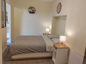 a bedroom with a bed and two lamps on a table at L'Atelier ,Calme, parking, centre Gémozac in Gémozac