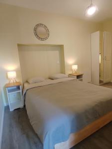 ein Schlafzimmer mit einem großen Bett und zwei Nachttischen in der Unterkunft L'Atelier T2 entièrement rénover in Gémozac
