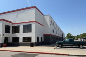 a green truck parked in front of a building at Coratel Inn and Suites By Jasper Wichita North in Wichita +20 photos