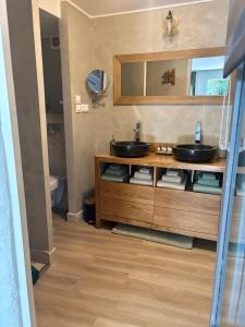une salle de bain avec deux lavabos et un miroir dans l'établissement La Bastide de Canaules, à Canaules-et-Argentières