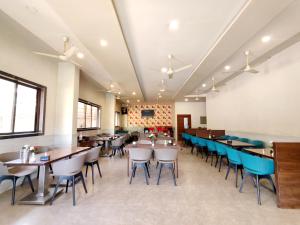 a dining room with tables and blue chairs at Sai Paradise lodging and Boarding in Dombivli