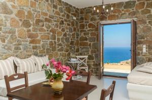 a living room with a table and a stone wall at Casa Borealis in Naxos Chora