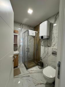 a bathroom with a toilet and a glass shower at BREATHE - Apartmani Zlatibor Centar in Zlatibor +48 photos