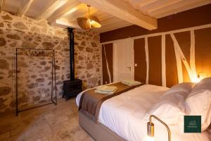 a bedroom with a bed and a stone wall at L'Ecrin de Soligny in Soligny-les-Étangs +12 photos
