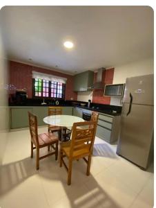 a kitchen with a table and chairs and a refrigerator at Casa de Praia in Bertioga