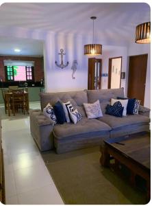 a living room with a couch with pillows on it at Casa de Praia in Bertioga