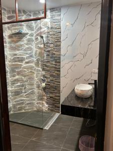 a bathroom with a shower with a stone wall at Samui Hills Resort in Amphoe Koh Samui
