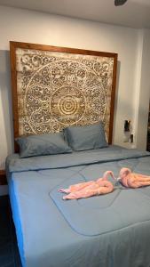 two pink flamingos are laying on a bed at Samui Hills Resort in Amphoe Koh Samui