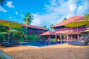 a resort with a swimming pool and yellow umbrellas at Celestia Ayurveda Resort in Bentota