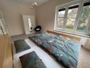 a bed in a room with two windows at Ferienwohnung Lahann in Saalfeld