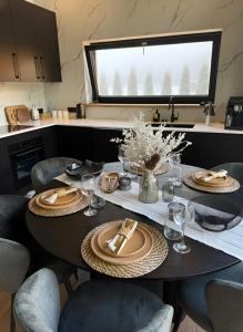 a dining room table with plates and glasses on it at Green Field Villa in Kuressaare