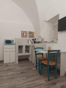 een keuken met een tafel en stoelen in een kamer bij ACQUAMARINA - Home & Relax in Ascoli Satriano