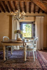 a dining room with a table and chairs and a window at Agriturismo La Frattina in Buonconvento