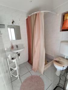 un bagno con tenda da doccia e lavandino di BB House a Balatonboglár