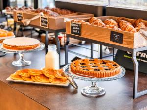 un panificio con torte e pasticcini su un bancone di B&B Hotel Milano Aosta a Milano