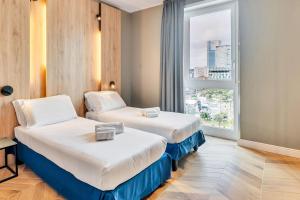 una camera d'albergo con due letti e una finestra di B&B Hotel Milano Aosta a Milano