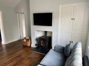 un soggiorno con divano e camino di The Priory Cottage a Legbourne