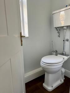 bagno con servizi igienici bianchi in camera di The Priory Cottage a Legbourne Altre 13 foto