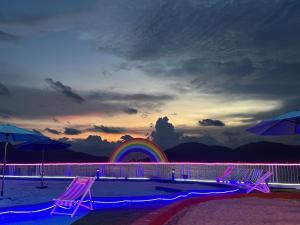 a group of chairs on a beach with a rainbow at IRONMAN HomeStay in Lumut +5 photos