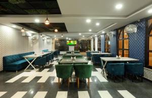 ニューデリーにあるHotel Luxury Suites Near IGI Airportのテーブルと椅子とテレビがあるレストラン