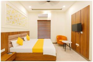 a bedroom with a bed and a television in it at Mahavidya Road Hotel The Shrinath Premium Palace Near Masani Railway Station - Sri Krishna Janmabhoomi - Parking # Restaurant And Lift facilities - Fully Air conditioning Luxuary Room - Top Rated Hotel In Mathura in Mathura +16 photos