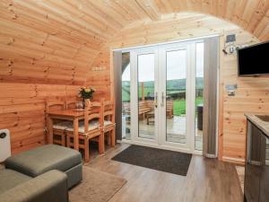 een blokhutwoonkamer met een tafel en een balkon bij Oak in Ulverston +19 foto's