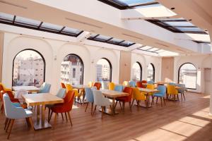 ein Restaurant mit Tischen, Stühlen und Fenstern in der Unterkunft فندق منسي Monsi Hotel in Ta'if
