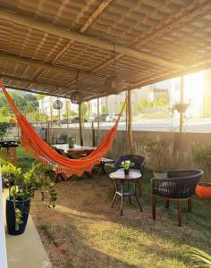 Apartamento térreo com jardim privativo في بارناميريم: أرجوحة تحت البرغولية مع طاولة وكراسي