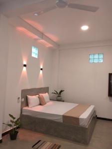 een slaapkamer met een bed met verlichting aan het plafond bij ASHI VILLA in Galle