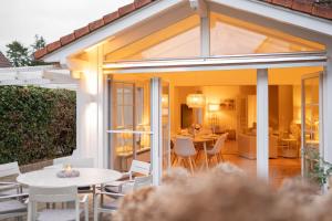 a conservatory with a table and chairs and a dining room at NEU Hütthus Ferienhaus in Timmendorfer Strand in Timmendorfer Strand