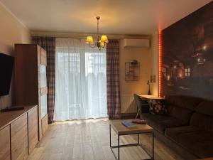 een woonkamer met een bank en een tafel bij Apartament Dębowy Stół in Rzeszów