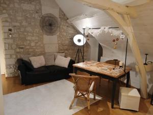a living room with a table and a couch at La parenthèse bucolique in Sepmes