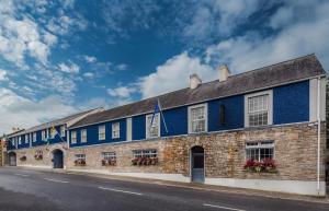 um edifício azul com janelas e flores numa rua em Breffni Arms Hotel em Arvagh