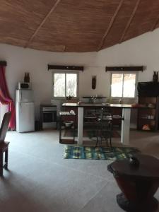 una camera con cucina completa di tavolo e frigorifero di Villa 150 mètres Océan a Cap Skirring