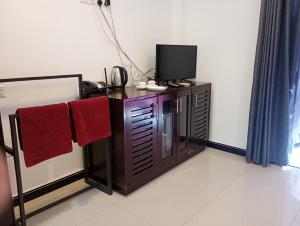 a room with a desk with a tv and red towels at Amelia resort in Udawalayagama