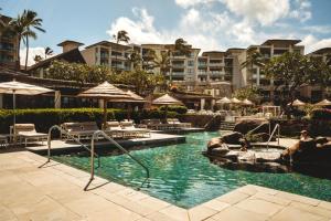 a swimming pool with chairs and umbrellas in a resort at NEW KBM Resorts FREE CAR Hale Nalu At Montage Kapalua Bay Sleeps 10 Oceanfront 3-Bedroom Condo with Daily Housekeeping Spa MON-6302 in Honokahua