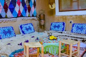 a room with a bed with two chairs and a table at MAISON D'HOTE DAR IMRANE in Tatta