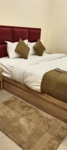 uma cama com cabeceira vermelha e almofadas em Hotel SJ corporate em Bhubaneshwar