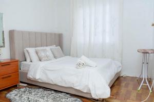 Nawii BNB في إلدوريت: غرفة نوم بها سرير بملاءات بيضاء ونافذة