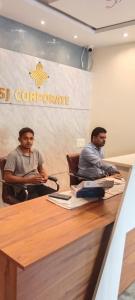 dois homens sentados à mesa em uma sala de conferências em Hotel SJ corporate em Bhubaneshwar