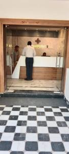 um homem parado em frente a um balcão numa loja em Hotel SJ corporate em Bhubaneshwar