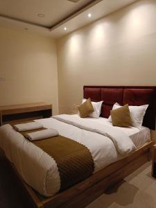 um quarto com uma cama grande e uma cabeceira vermelha em Hotel SJ corporate em Bhubaneshwar