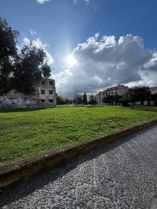 a field of green grass next to a street at CR Home in Palermo