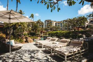 a group of chairs and a table and an umbrella at KBM Resorts FREE CAR Lxuury Ocean View Villa Palapala at Montage Kapalua Bay Daily Housekeeping and world-class spa MON-1304 in Honokahua